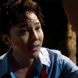 A Close Up Of A Man 'S Face With A Blue Shirt And Red Tie . GIF