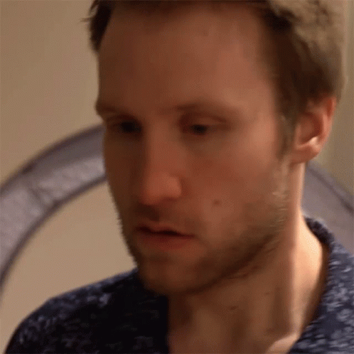 A Close Up Of A Man 'S Face With A Blue Shirt GIF