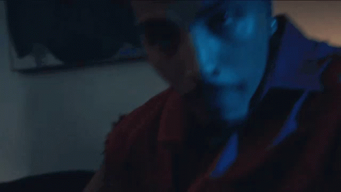 A Close Up Of A Man 'S Face With A Blue Shirt That Says ' A ' On It GIF