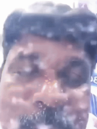 A Close Up Of A Man 'S Face With A Blurred Background And A Bottle Of Coca Cola In The Background GIF