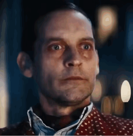 A Close Up Of A Man 'S Face With A Blurred Background And A Polka Dot Shirt . GIF