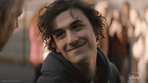 A Close Up Of A Man 'S Face With A Disney Logo Behind Him GIF