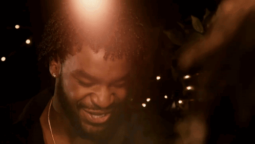 A Close Up Of A Man 'S Face With A Few Lights In The Background GIF