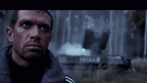 a close up of a man 's face with a fire behind him