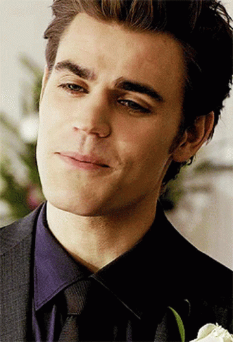 A Close Up Of A Man 'S Face With A Flower In The Foreground GIF