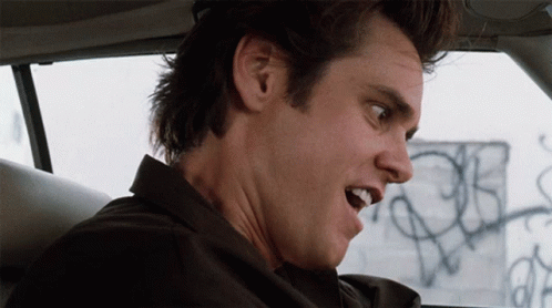 A Close Up Of A Man 'S Face With A Graffiti Wall In The Background GIF