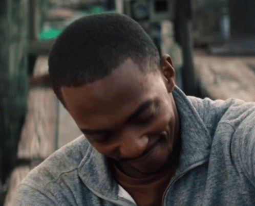 A Close Up Of A Man 'S Face With A Gray Sweatshirt On GIF
