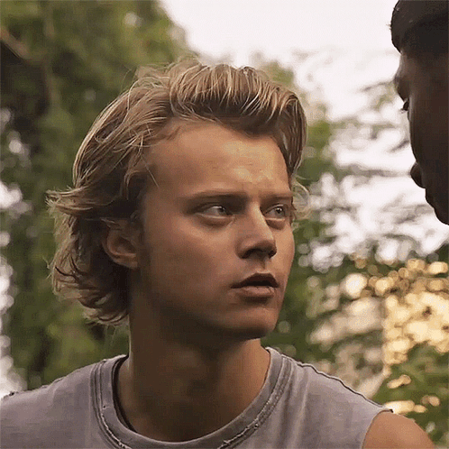 A Close Up Of A Man 'S Face With A Gray Tank Top On . GIF