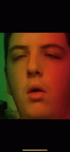 A Close Up Of A Man 'S Face With A Green Background GIF