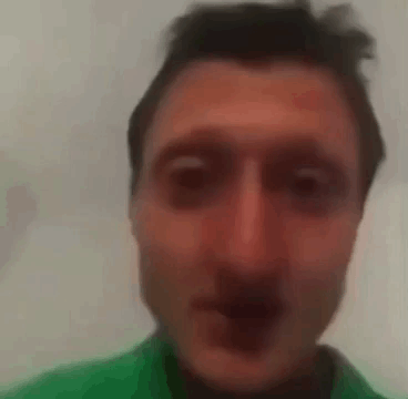 A Close Up Of A Man 'S Face With A Green Shirt On . GIF