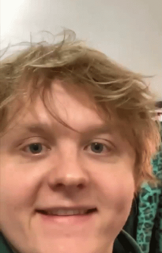 A Close Up Of A Man 'S Face With A Green Shirt On GIF