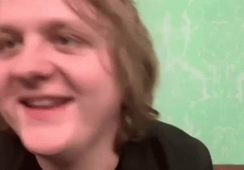A Close Up Of A Man 'S Face With A Green Wall In The Background . GIF