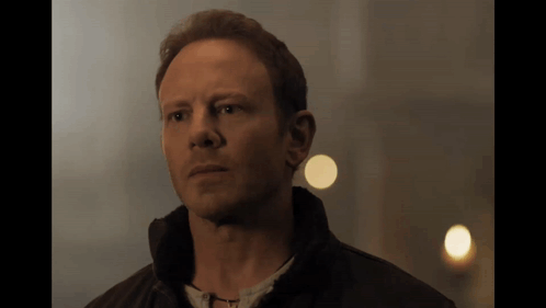 A Close Up Of A Man 'S Face With A Light Behind Him GIF