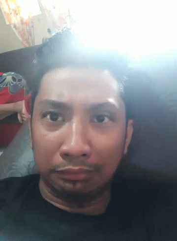 A Close Up Of A Man 'S Face With A Light Shining On It GIF