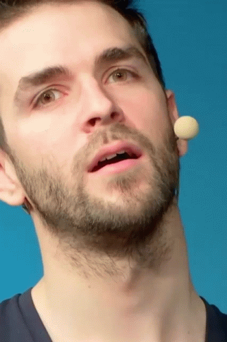 A Close Up Of A Man 'S Face With A Microphone Behind His Ear GIF