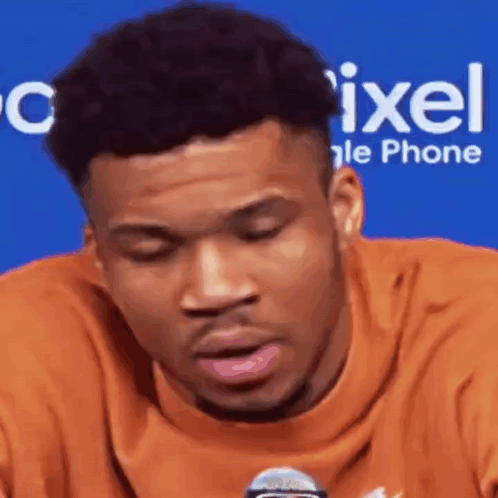 A Close Up Of A Man 'S Face With A Microphone In Front Of Him . GIF