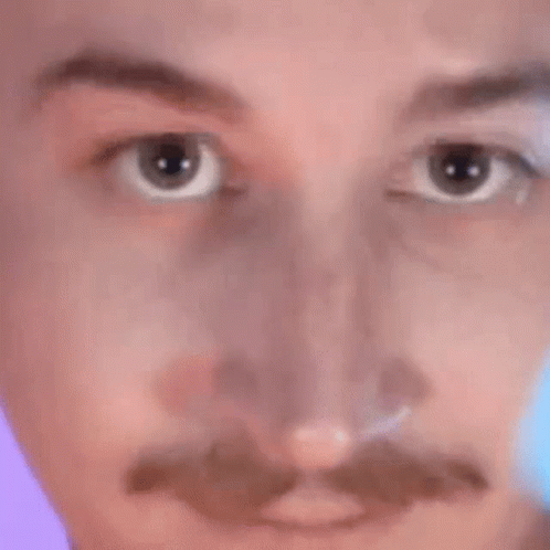 A Close Up Of A Man 'S Face With A Mustache And A Purple Background . GIF