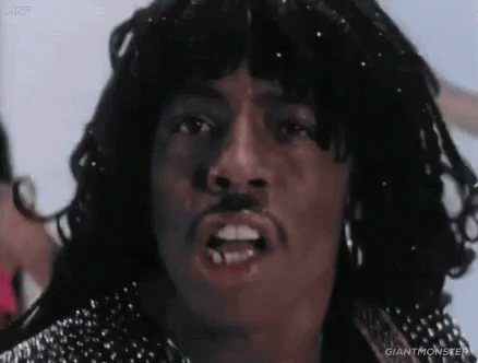A Close Up Of A Man 'S Face With A Mustache And Earrings . GIF