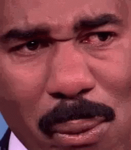 A Close Up Of A Man 'S Face With A Mustache And Red Eyes . GIF