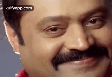 A Close Up Of A Man 'S Face With A Mustache Smiling . GIF
