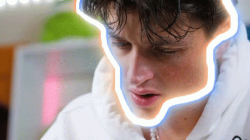 A Close Up Of A Man 'S Face With A Neon Line Around His Mouth GIF
