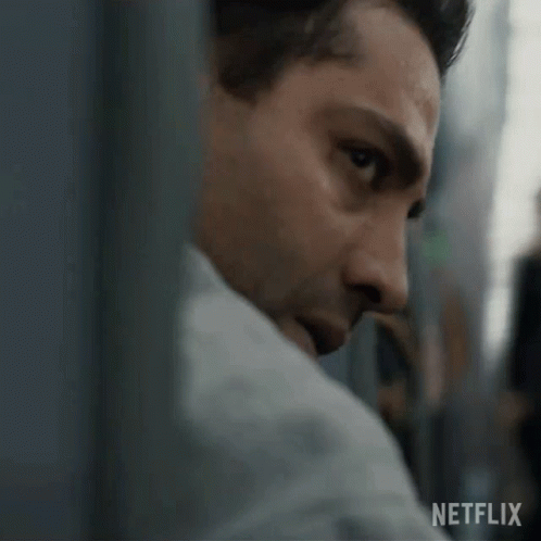 A Close Up Of A Man 'S Face With A Netflix Logo In The Background . GIF