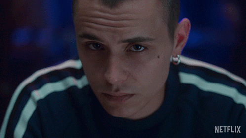 A Close Up Of A Man 'S Face With A Netflix Logo In The Background GIF