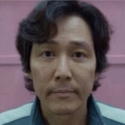 A Close Up Of A Man 'S Face With A Pink Background And A Blurred Background . GIF