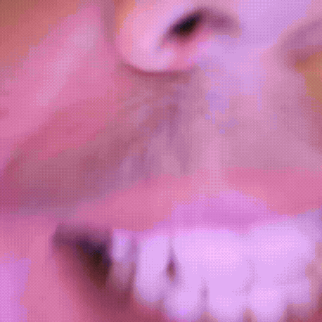 a close up of a man 's face with a pink background