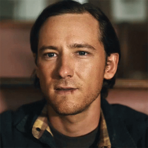 A Close Up Of A Man 'S Face With A Plaid Shirt On GIF