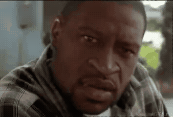A Close Up Of A Man 'S Face With A Plaid Shirt On GIF