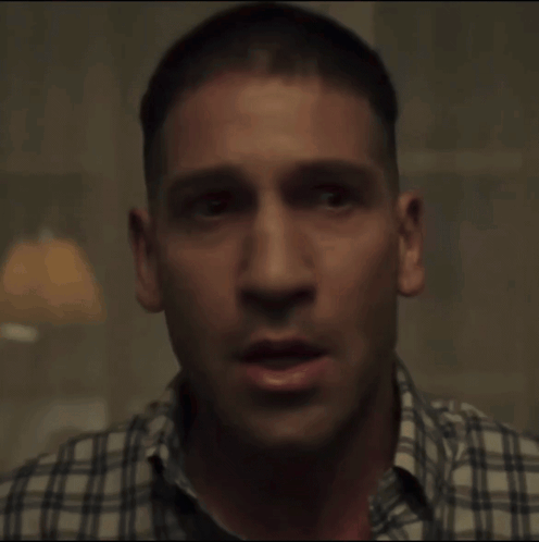 A Close Up Of A Man 'S Face With A Plaid Shirt GIF