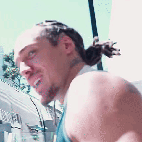 A Close Up Of A Man 'S Face With A Ponytail GIF