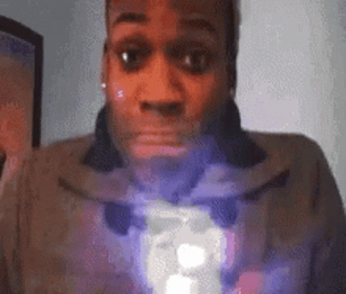 A Close Up Of A Man 'S Face With A Purple Light Coming Out Of His Mouth GIF