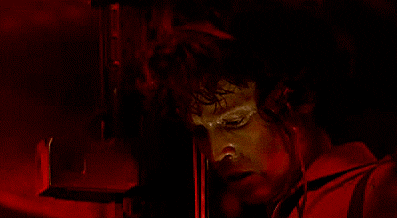 A Close Up Of A Man 'S Face With A Red Light Behind Him GIF