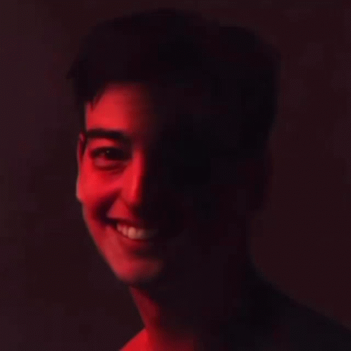 A Close Up Of A Man 'S Face With A Red Light Shining On His Face . GIF