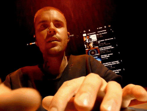 A Close Up Of A Man 'S Face With A Screen Behind Him That Says ' Youtube ' On It GIF