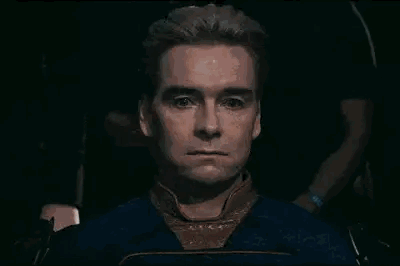 A Close Up Of A Man 'S Face With A Serious Look On His Face In A Dark Room . GIF