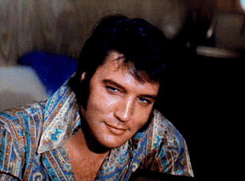 A Close Up Of A Man 'S Face With A Shirt That Says ' Elvis Presley ' On It GIF