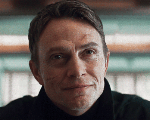 A Close Up Of A Man 'S Face With A Slight Smile On His Face GIF