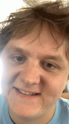 A Close Up Of A Man 'S Face With A Slight Smile On His Face GIF