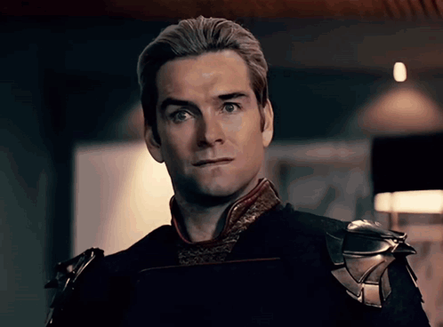 A Close Up Of A Man 'S Face With A Slight Smirk On His Face GIF