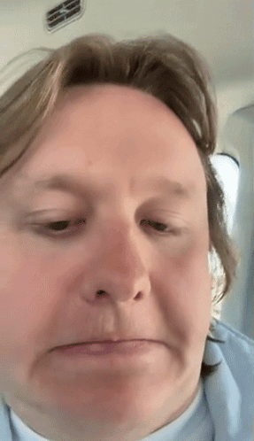 A Close Up Of A Man 'S Face With A Slight Smirk On His Face GIF