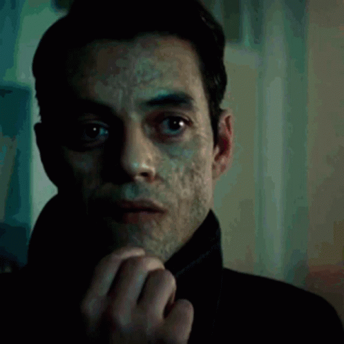A Close Up Of A Man 'S Face With A Slight Smirk On His Face GIF