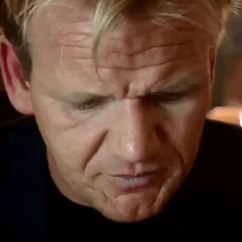 A Close Up Of A Man 'S Face With A Slight Smirk On It . GIF