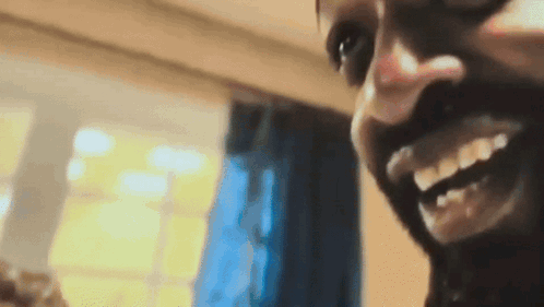 A Close Up Of A Man 'S Face With A Smile On His Face GIF