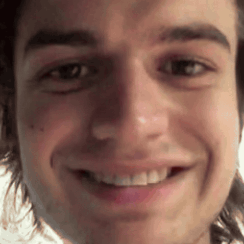 A Close Up Of A Man 'S Face With A Smile On It GIF