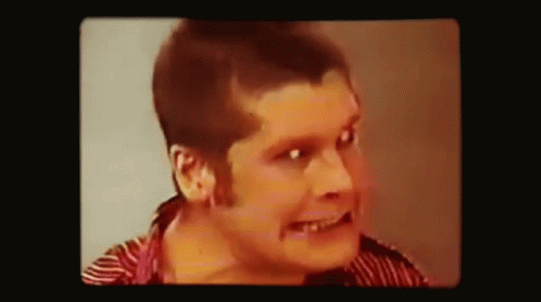 A Close Up Of A Man 'S Face With A Striped Shirt On . GIF