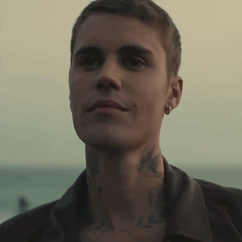 A Close Up Of A Man 'S Face With A Tattoo On His Neck And Earring GIF
