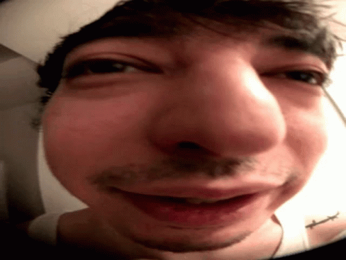 A Close Up Of A Man 'S Face With A Tattoo On His Shoulder GIF